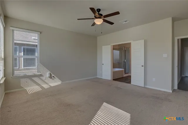 a view of a room with a ceiling fan and window