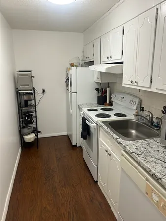 a kitchen with a sink a refrigerator and cabinets