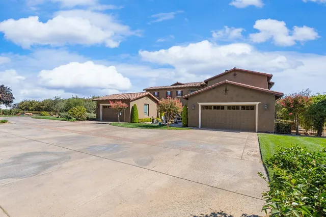 a large kitchen with stainless steel appliances granite countertop a stove a sink dishwasher and a dining table with the living room view
