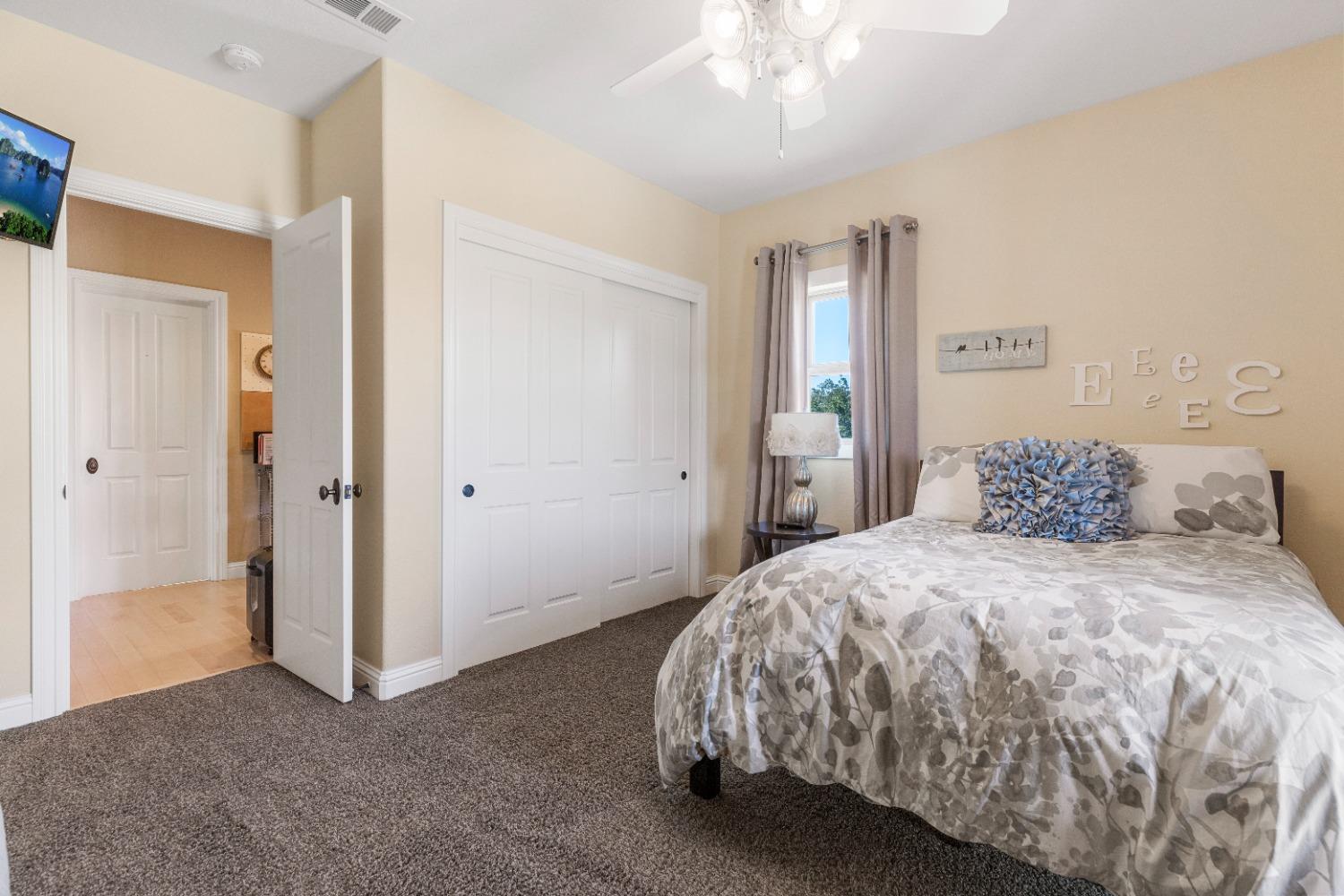 618 Elfers Road Patterson, CA 95363 - Photo 68 of 79 a spacious bedroom with a bed and a chandelier
