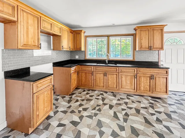 a bathroom with a granite countertop toilet and a sink