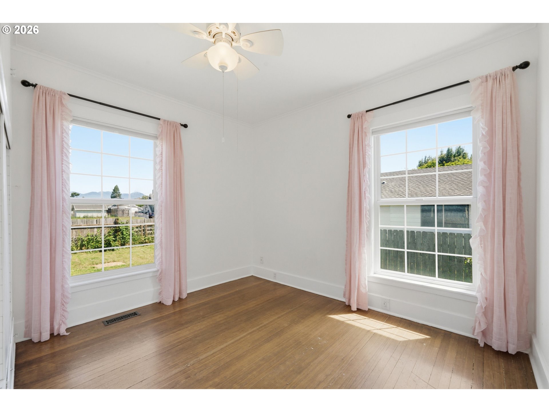1802 8th Street Tillamook, OR 97141 - Photo 22 of 37 an empty room with wooden floor and windows