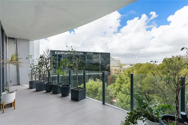 a view of a big room with wooden floor and a kitchen