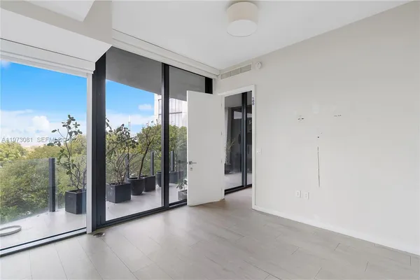 a view of a room with wooden floor and sliding glass door