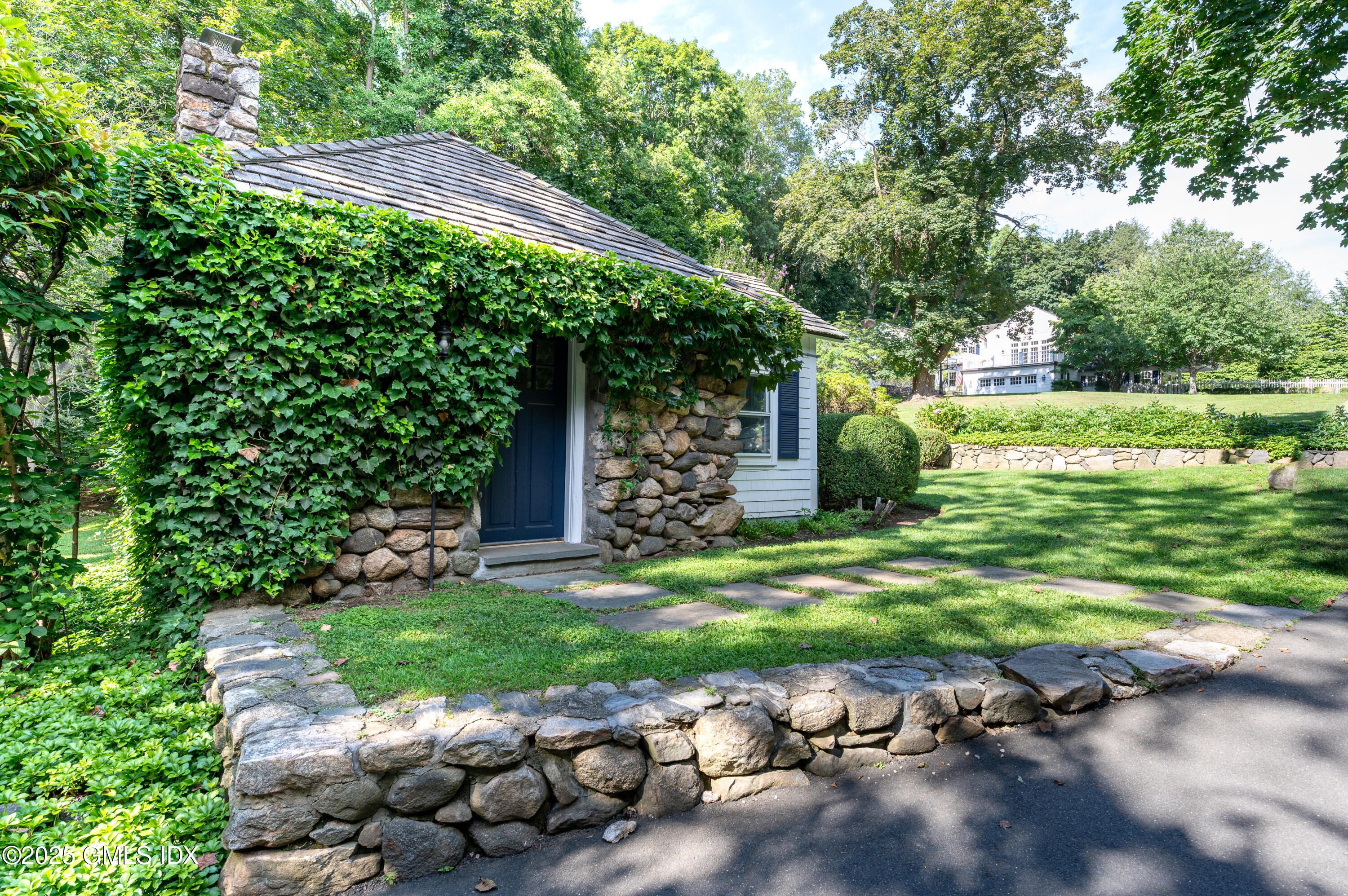 40 Ridgeview Avenue Greenwich, CT 06830 - Photo 33 of 38 a backyard of a house with table and chairs under an umbrella