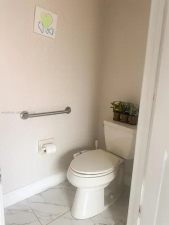 a white toilet sitting next to a shower