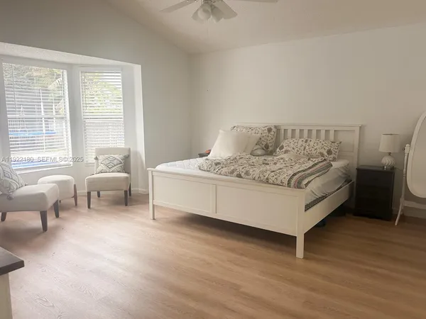 a spacious bedroom with a bed and a couch next to a window