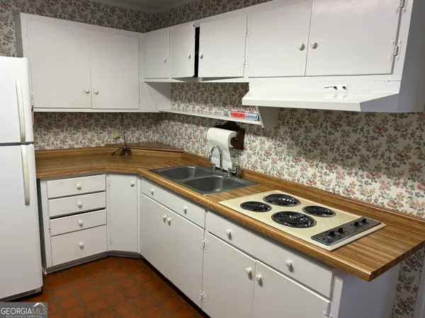 a kitchen with white cabinets and appliances
