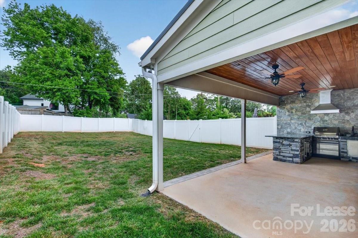 5201 Valley Stream Road Charlotte, NC 28209 - Photo 11 of 47 a view of a backyard with table and chairs under an umbrella with a small yard