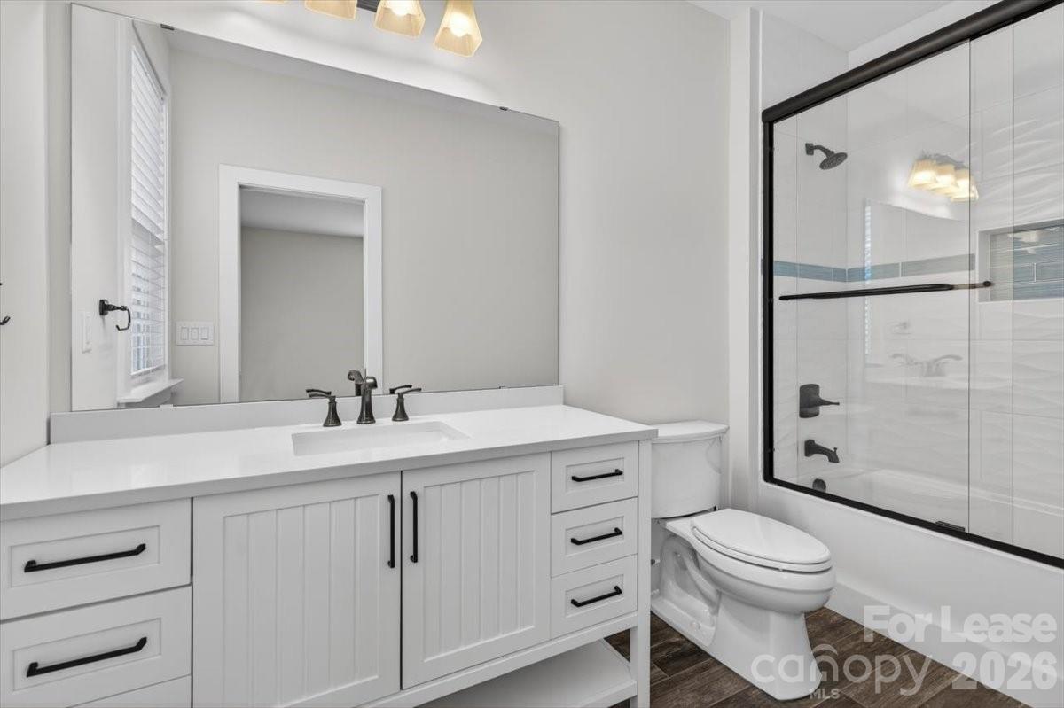 5201 Valley Stream Road Charlotte, NC 28209 - Photo 19 of 47 a bathroom with a toilet a sink and shower