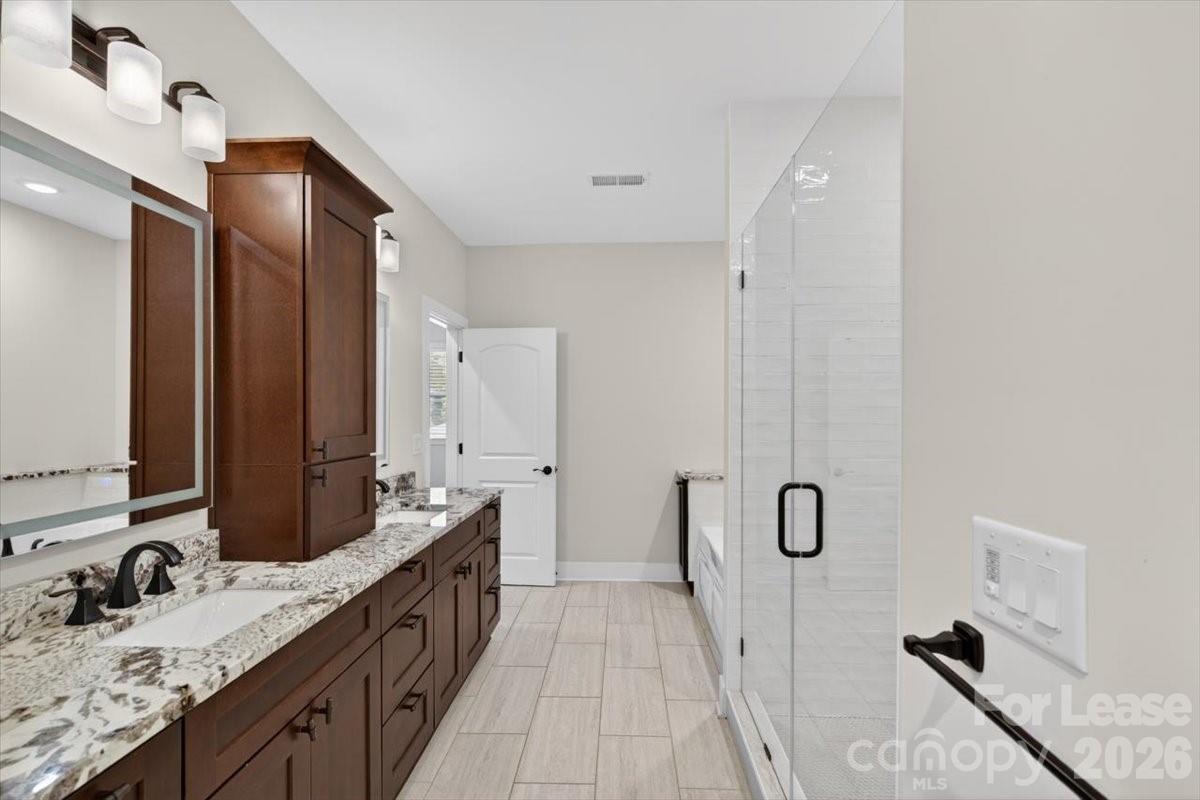 5201 Valley Stream Road Charlotte, NC 28209 - Photo 28 of 47 a spacious bathroom with double vanity and a mirror