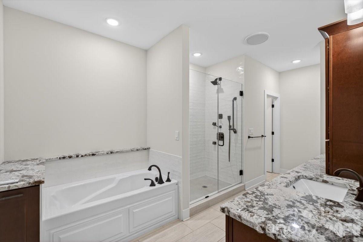 5201 Valley Stream Road Charlotte, NC 28209 - Photo 29 of 47 a bathroom with a tub sink shower and a mirror