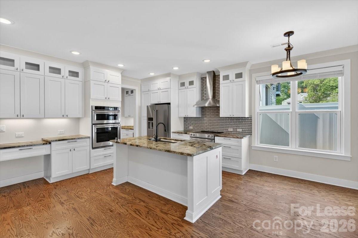 5201 Valley Stream Road Charlotte, NC 28209 - Photo 36 of 47 a kitchen with stainless steel appliances granite countertop a stove a sink and a refrigerator