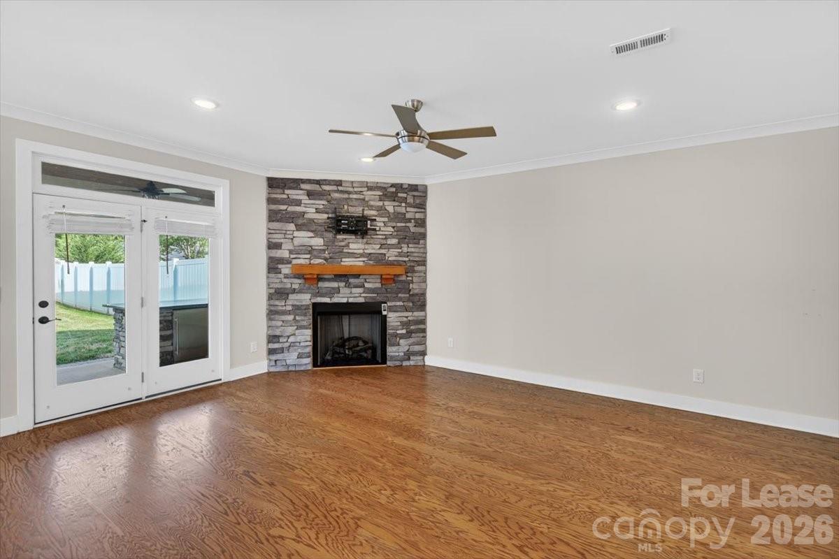 5201 Valley Stream Road Charlotte, NC 28209 - Photo 39 of 47 an empty room with windows fireplace and a ceiling fan