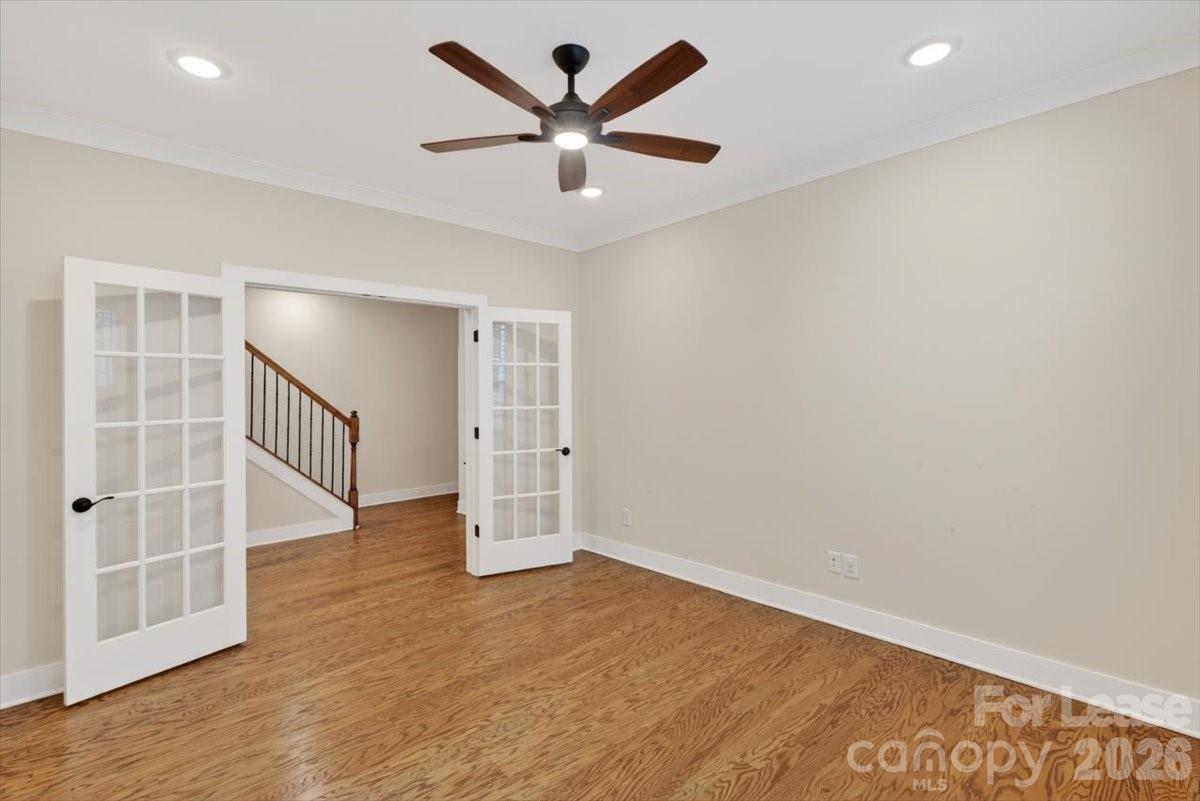 5201 Valley Stream Road Charlotte, NC 28209 - Photo 45 of 47 an empty room with wooden floor and a ceiling fan