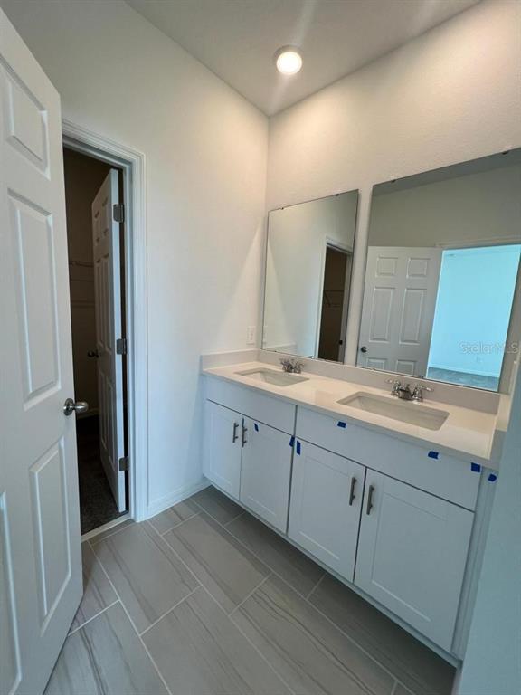 4638 Homestead Trail St. Cloud, FL 34772 - Photo 18 of 30 a bathroom with double sink and a mirror