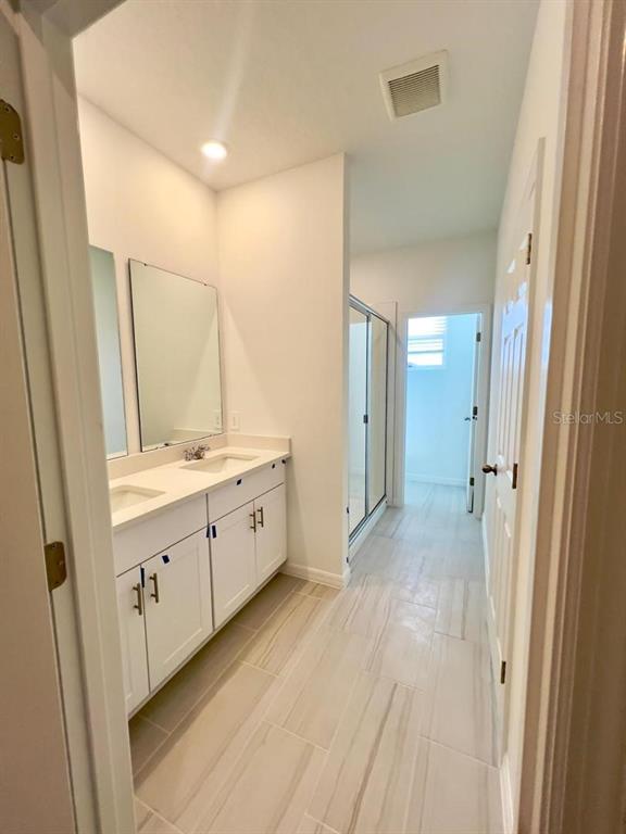 4638 Homestead Trail St. Cloud, FL 34772 - Photo 19 of 30 a bathroom with a sink mirror and a shower