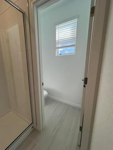 a view of a hallway with wooden floor and a living room
