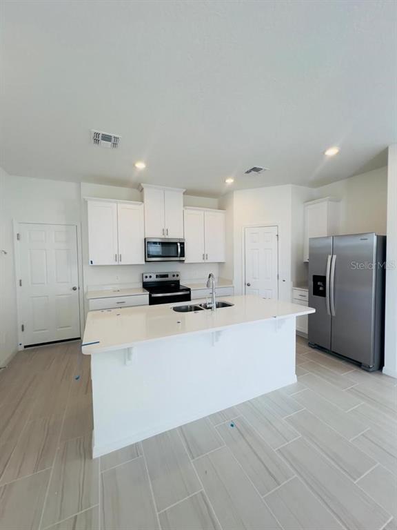 4638 Homestead Trail St. Cloud, FL 34772 - Photo 8 of 30 a large kitchen with stainless steel appliances a refrigerator a stove top oven a sink and cabinets