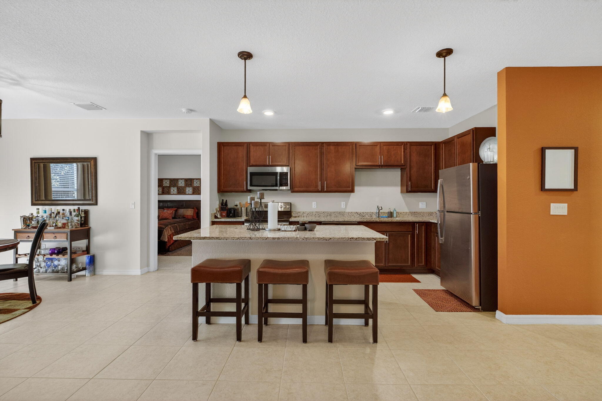 5221 Armina Place Fort Pierce, FL 34951 - Photo 8 of 40 a kitchen with stainless steel appliances granite countertop a refrigerator a stove a sink a dining table and chairs with wooden floor