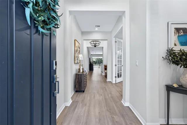 a kitchen with stove a sink dishwasher a dining table and chairs with wooden floor