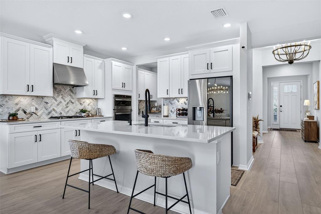 16106 Culpepper Drive Lakewood Ranch, FL 34211 - Photo 26 of 99 a kitchen with stainless steel appliances granite countertop a refrigerator and a stove top oven