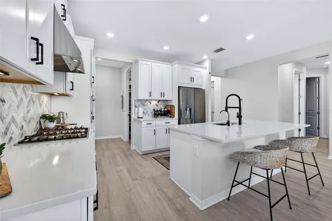 a view of a patio with a dining table and chairs under an umbrella