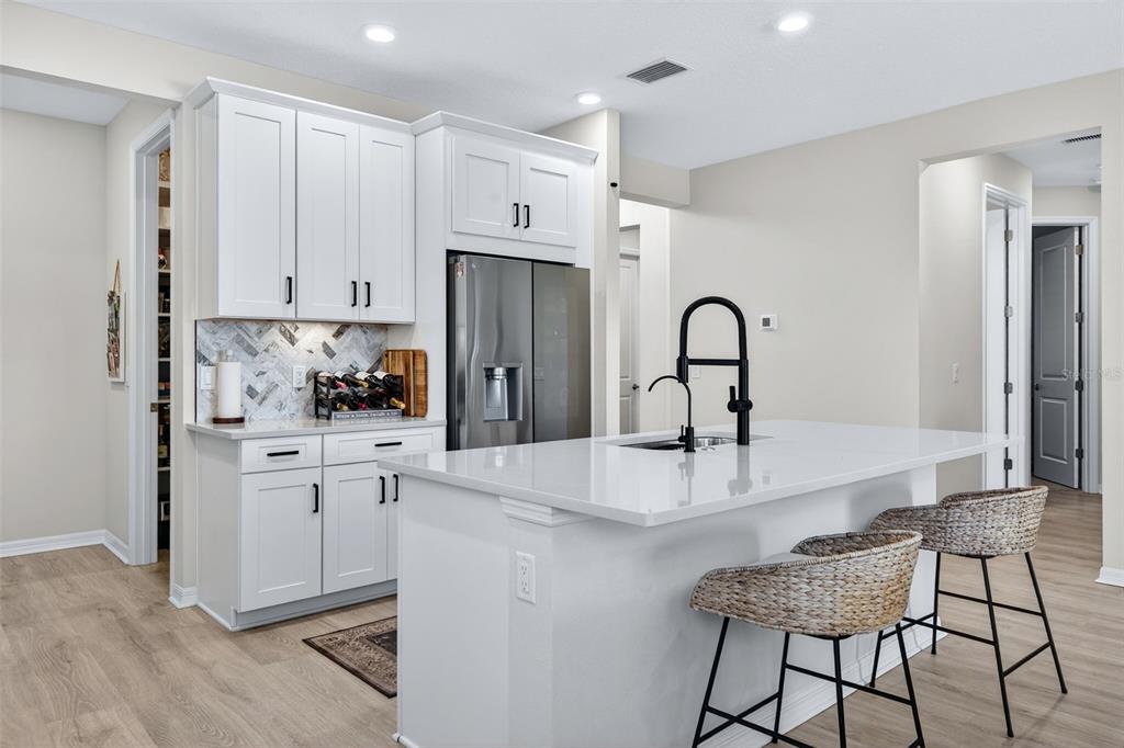 16106 Culpepper Drive Lakewood Ranch, FL 34211 - Photo 29 of 99 a kitchen with stainless steel appliances kitchen island a table chairs and a refrigerator