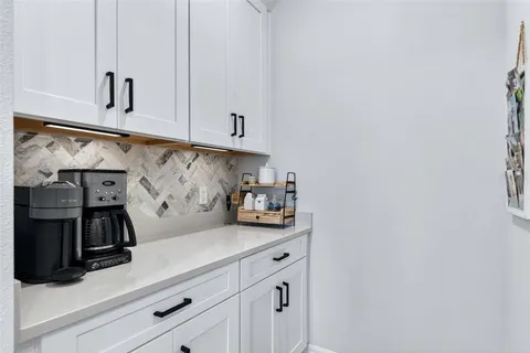 a view of a patio with a table and chairs under an umbrella