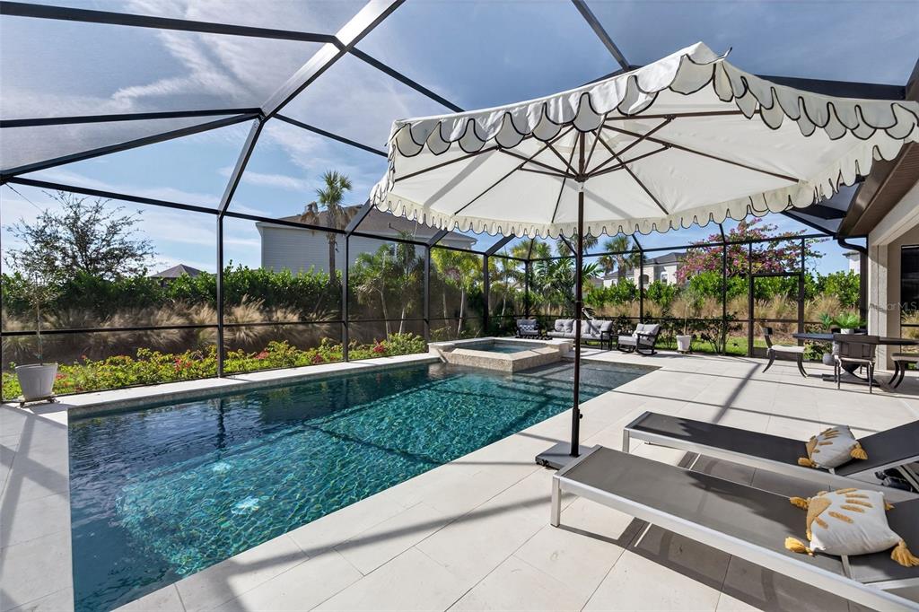 16106 Culpepper Drive Lakewood Ranch, FL 34211 - Photo 60 of 99 a view of a patio with a table and chairs under an umbrella