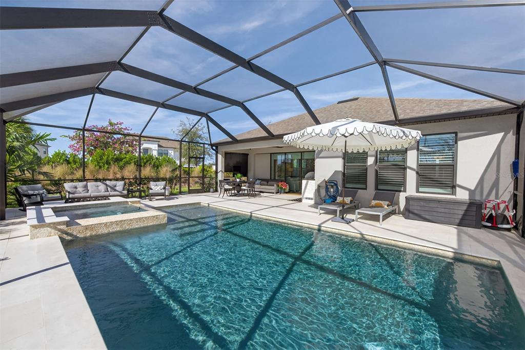 16106 Culpepper Drive Lakewood Ranch, FL 34211 - Photo 61 of 99 a view of a patio with a table and chairs under an umbrella