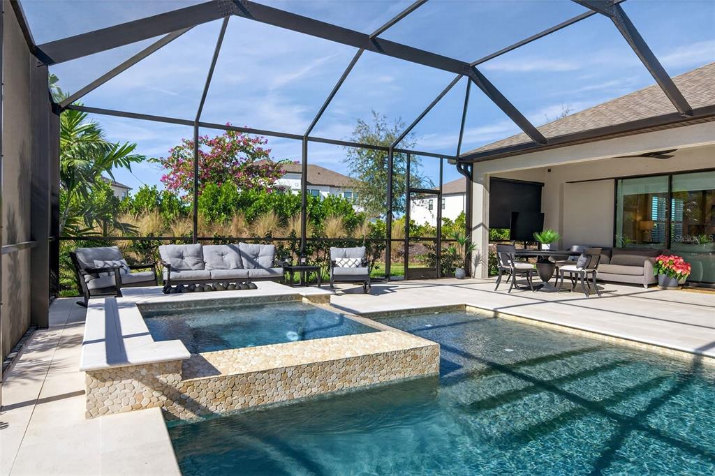 16106 Culpepper Drive Lakewood Ranch, FL 34211 - Photo 62 of 99 a view of a patio with a table and chairs under an umbrella