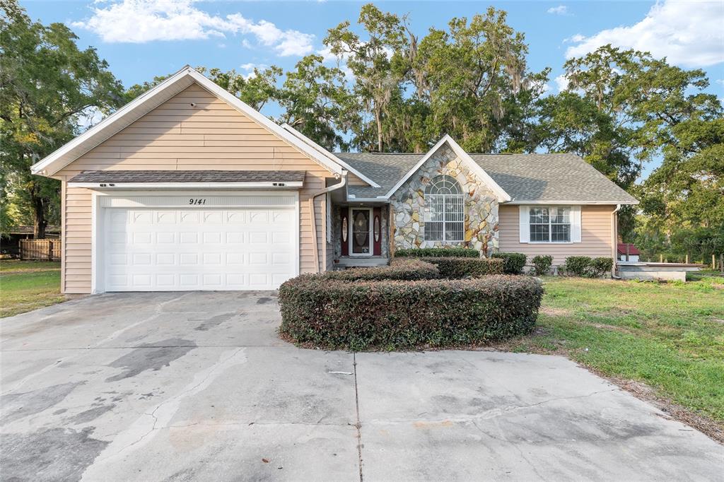 9161 Southwest 34th Place Ocala, FL 34481 - Photo 4 of 100 a front view of a house with a garden