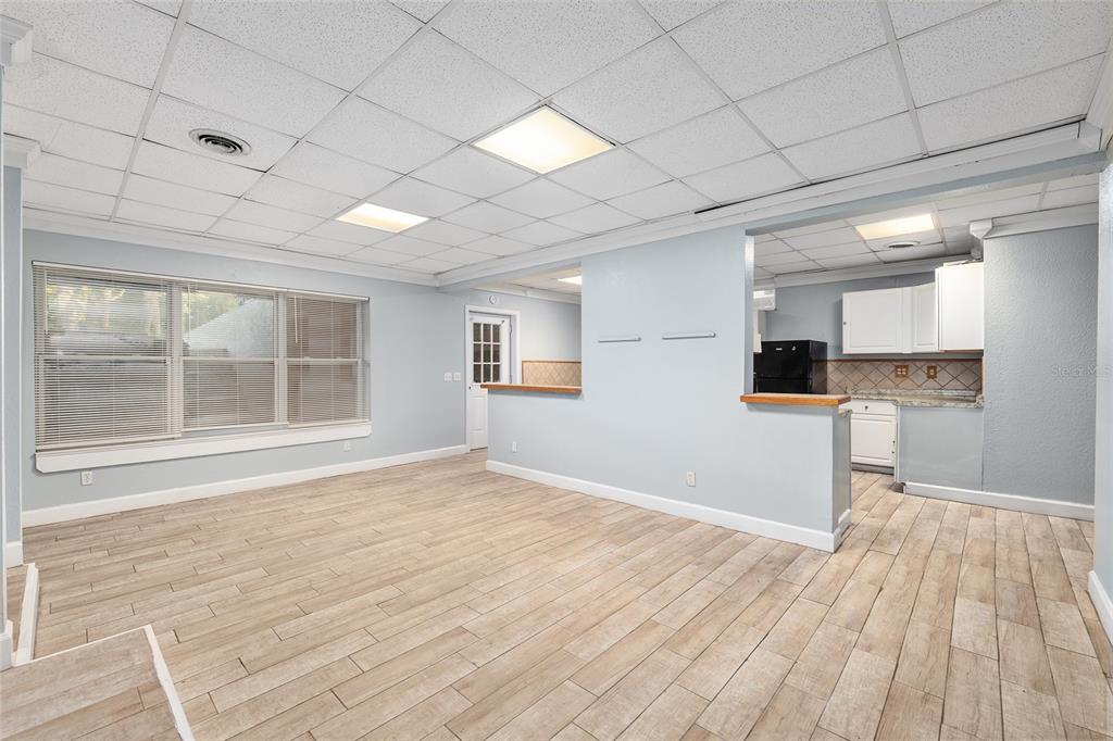 9161 Southwest 34th Place Ocala, FL 34481 - Photo 57 of 100 a view of empty room with wooden floor and kitchen view