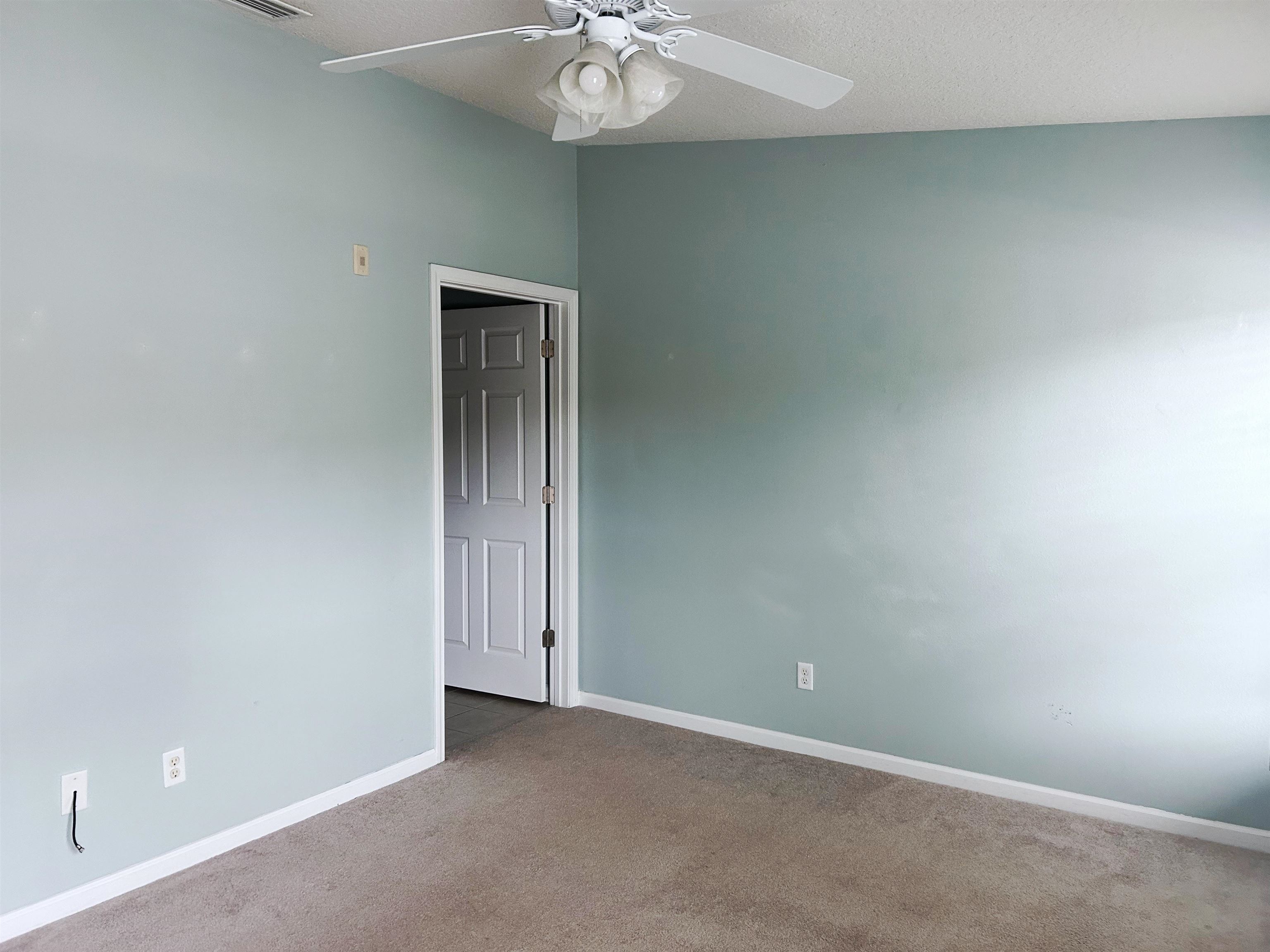 240 Golden Lake Loop St. Augustine, FL 32084 - Photo 11 of 28 an empty room with a chandelier fan and windows