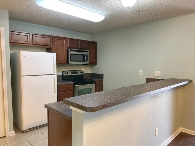 an empty room with a chandelier fan and windows