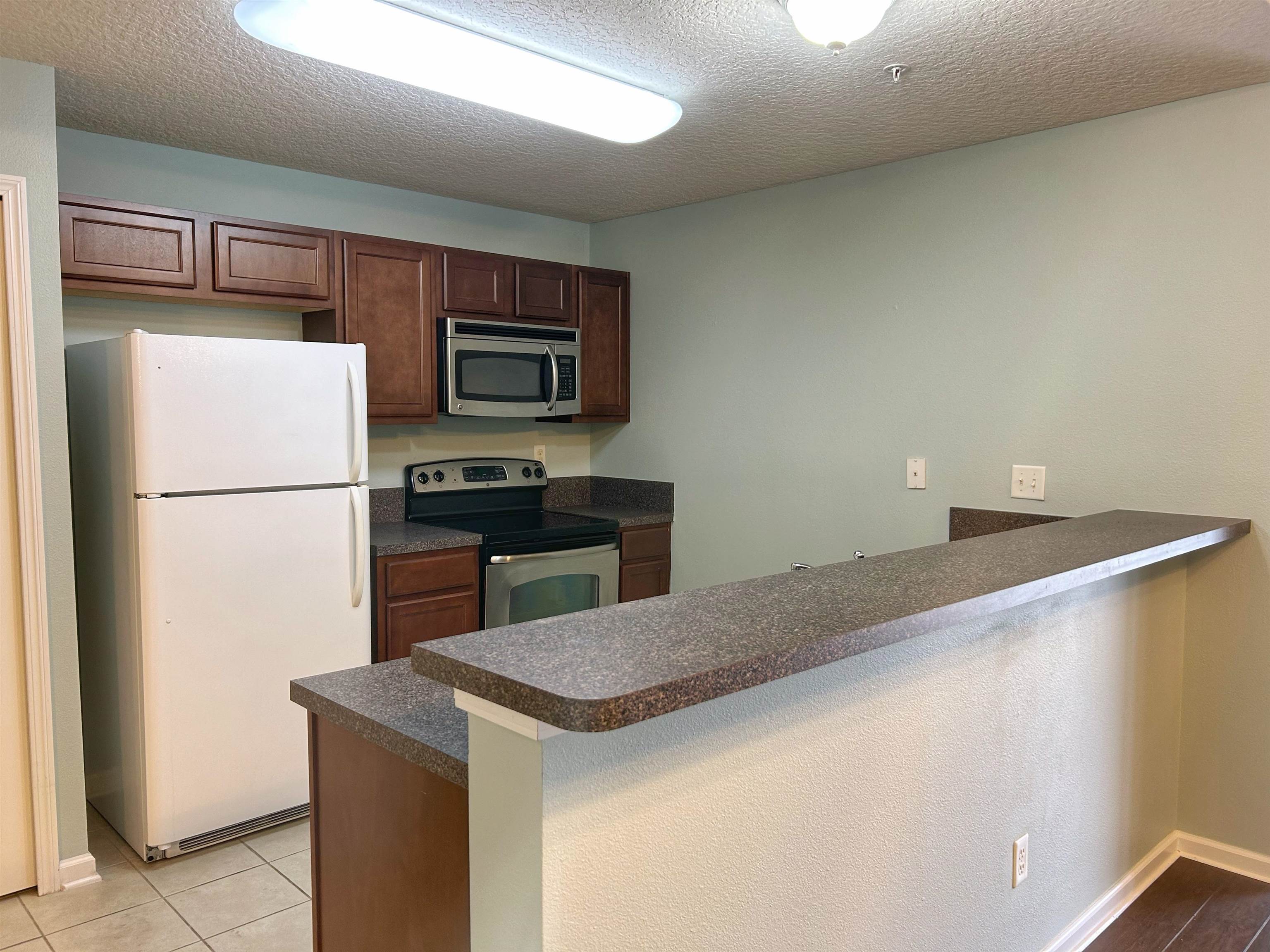 240 Golden Lake Loop St. Augustine, FL 32084 - Photo 6 of 28 a kitchen with stainless steel appliances a refrigerator and a stove top oven