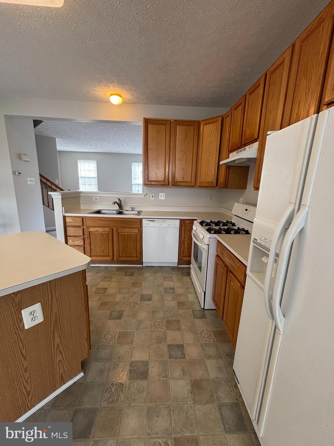 9804 Redwing Drive, Unit 9804 Perry Hall, MD 21128 - Photo 14 of 25 a kitchen with sink a refrigerator and cabinets