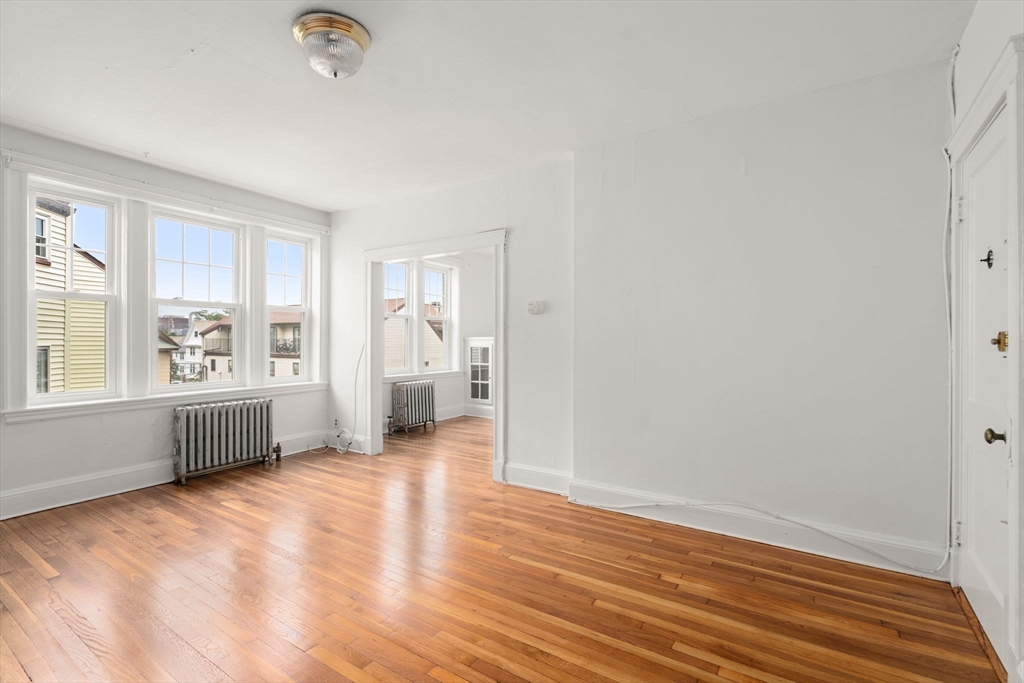 97 Chester Street, Unit 8 Boston, MA 02134 - Photo 13 of 19 wooden floor in an empty room with a window