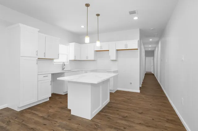 a kitchen with a sink a window stainless steel appliances and cabinets