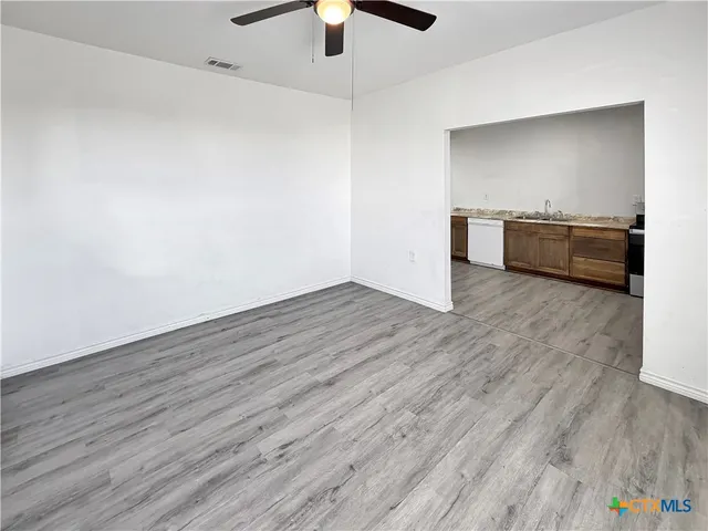 a view of a kitchen with a sink and wooden floor