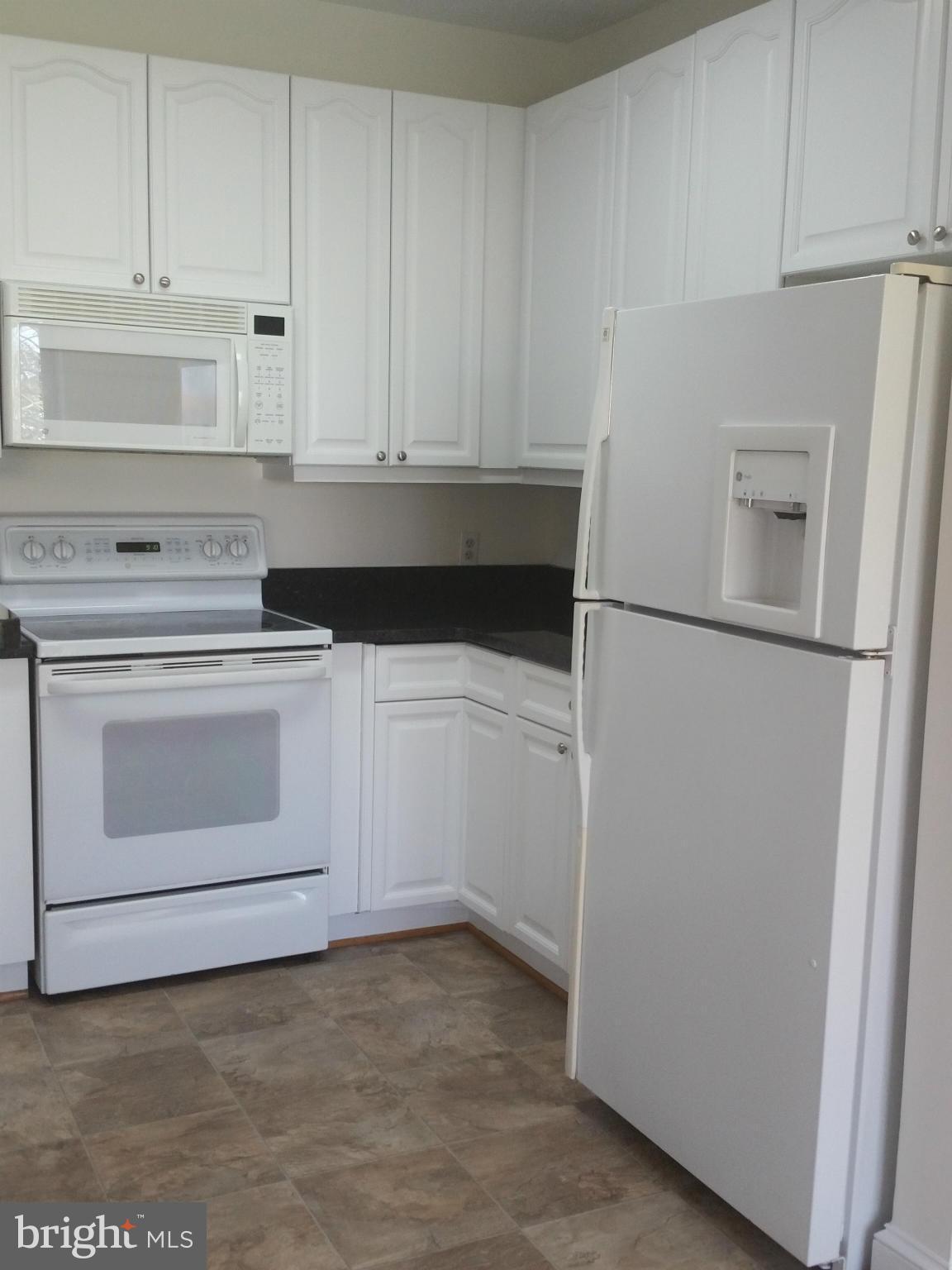 524 Runabout Loop, Unit 9 Solomons, MD 20688 - Photo 7 of 25 a kitchen with white cabinets and white stainless steel appliances