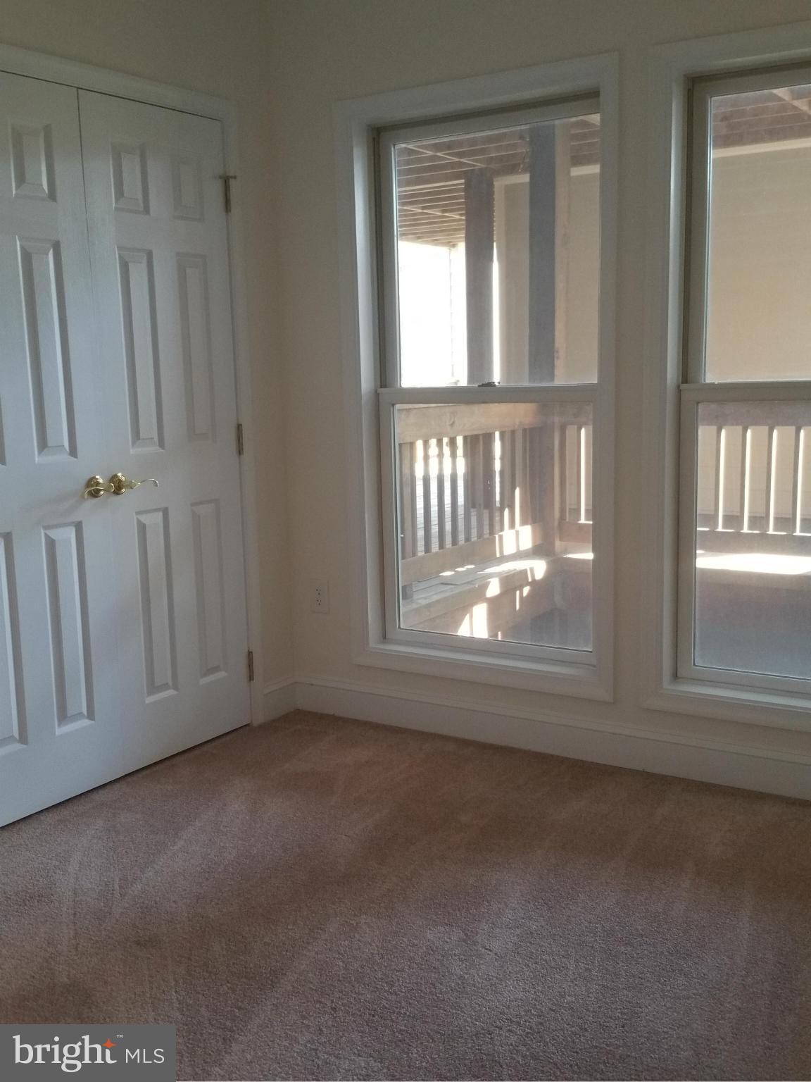 524 Runabout Loop, Unit 9 Solomons, MD 20688 - Photo 10 of 25 an empty room with wooden floor and a window