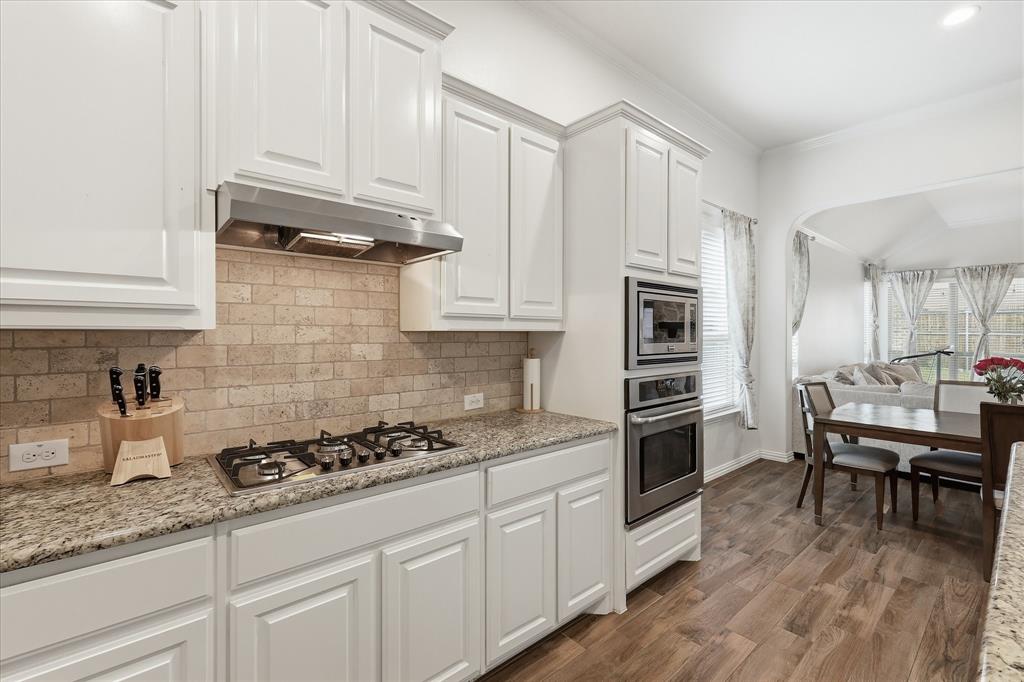 215 Equestrian Road Hickory Creek, TX 75065 - Photo 13 of 36 a kitchen with granite countertop cabinets and steel stainless steel appliances
