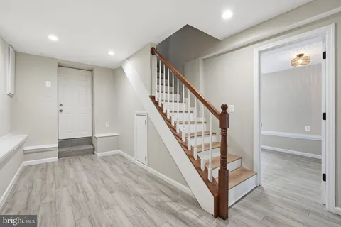 a view of an entryway with wooden floor and stairs