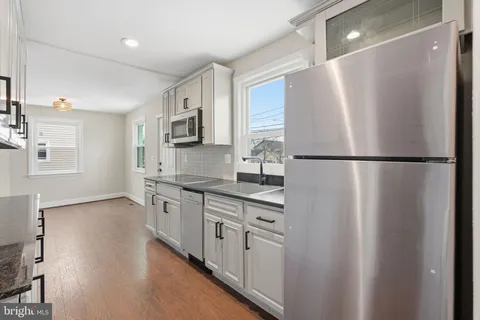 a kitchen with stainless steel appliances a refrigerator a sink a stove a microwave a sink and cabinets