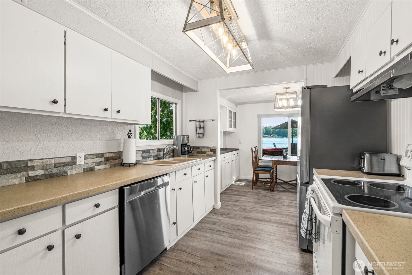 21 Shore Court Grapeview, WA 98546 - Photo 21 of 34 a kitchen with granite countertop a sink a counter space appliances and cabinets