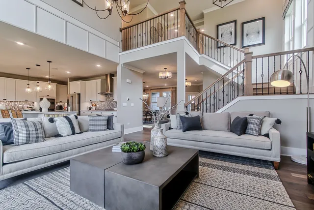 a living room with furniture kitchen view and a chandelier