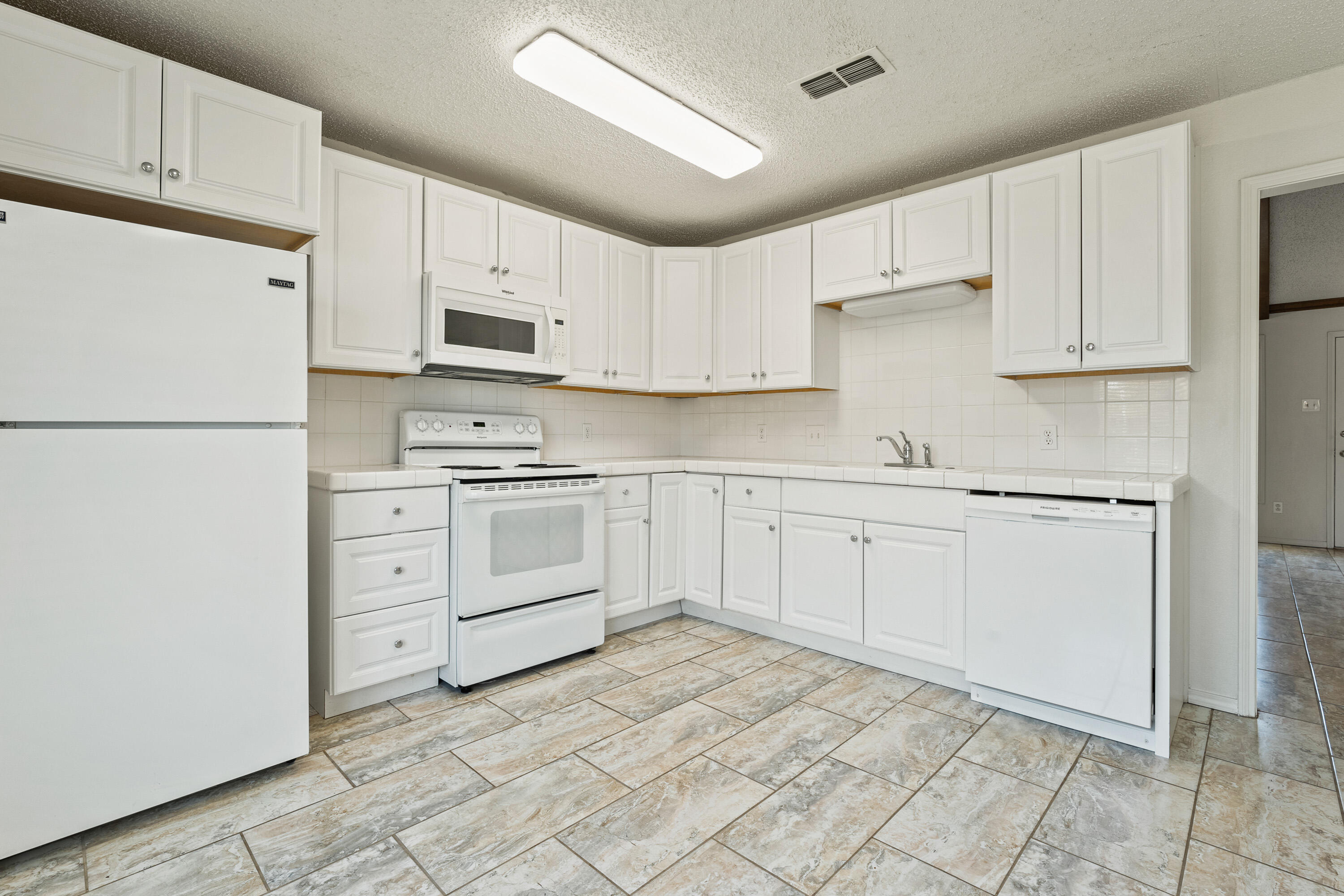7004 Wayne Avenue Lubbock, TX 79424 - Photo 15 of 29 a kitchen with white cabinets and white appliances