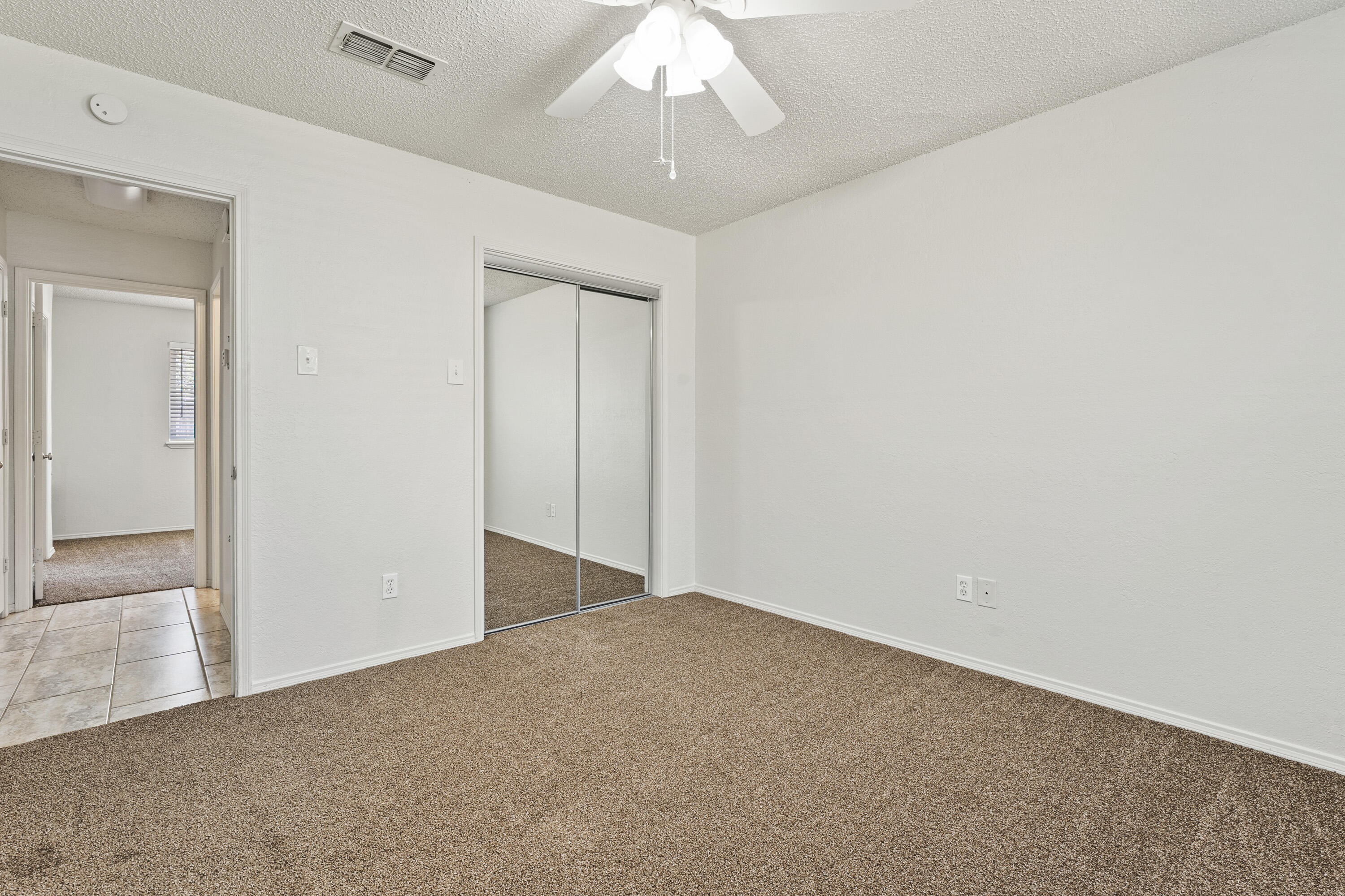 7004 Wayne Avenue Lubbock, TX 79424 - Photo 22 of 29 an empty room with a chandelier fan and wooden floor